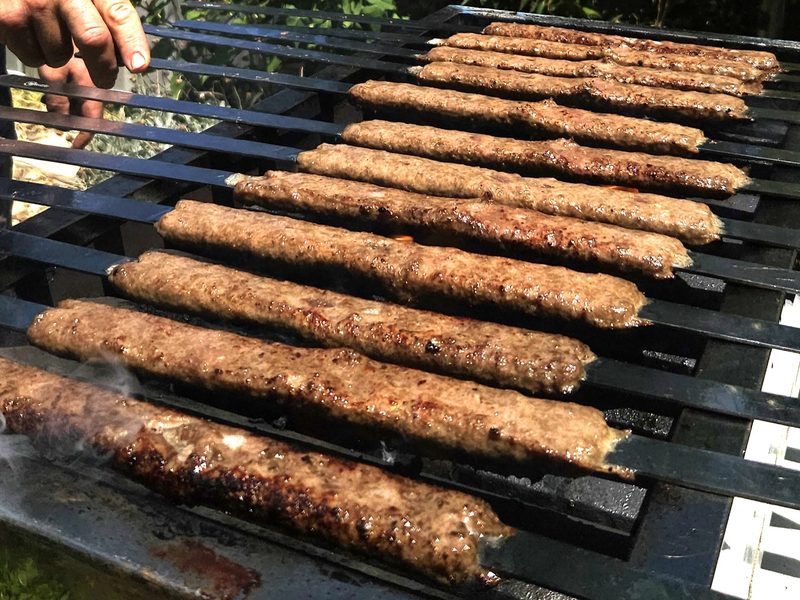 Koobideh minced meat kebabs sizzling on the grill