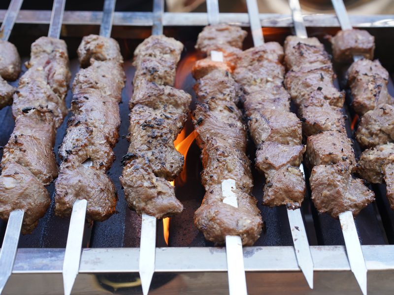 Lamb skewers chargrilling over open flame